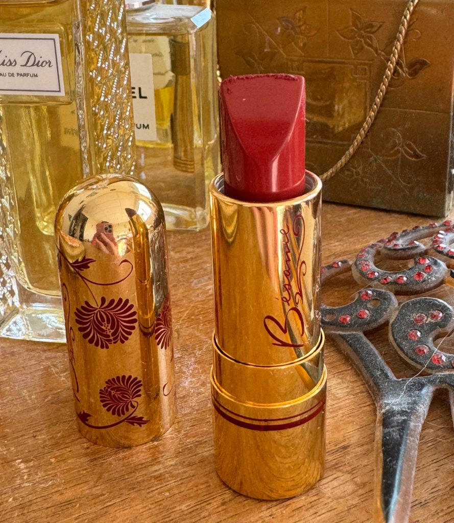 Lipstick on a dresser with perfume bottles