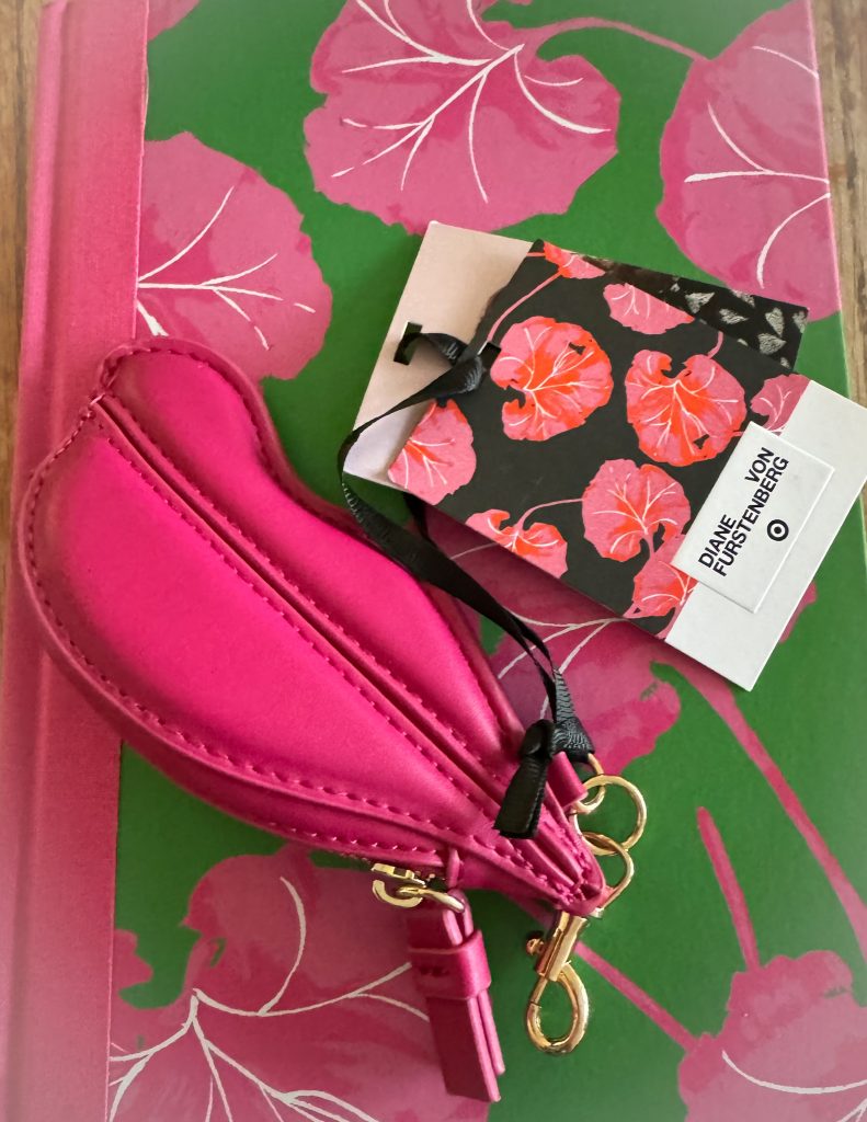 Coin purse on a notebook with pink flowers.