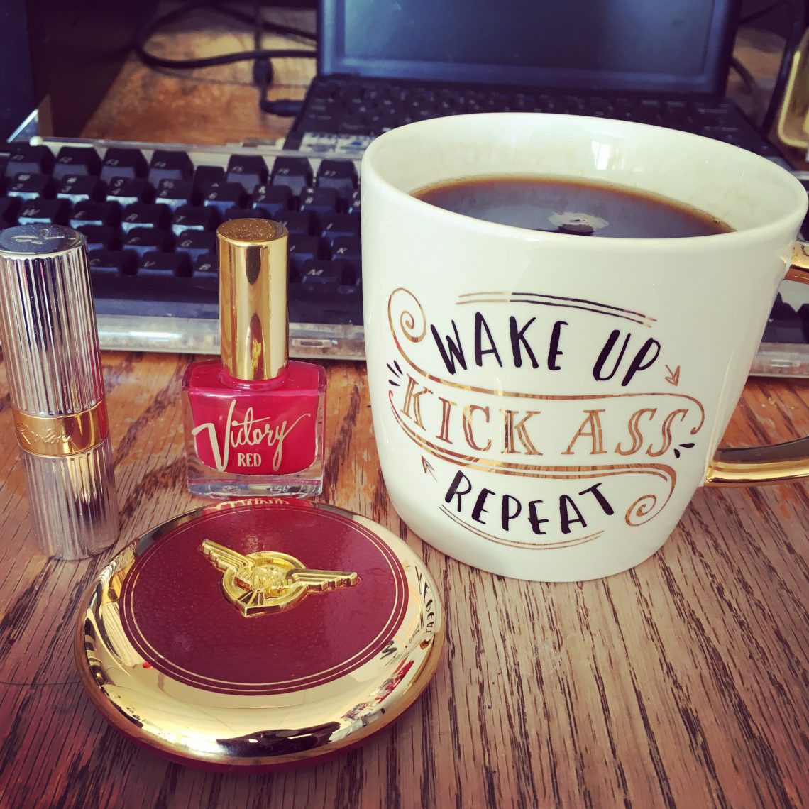 Coffee cup and makeup items on a table.