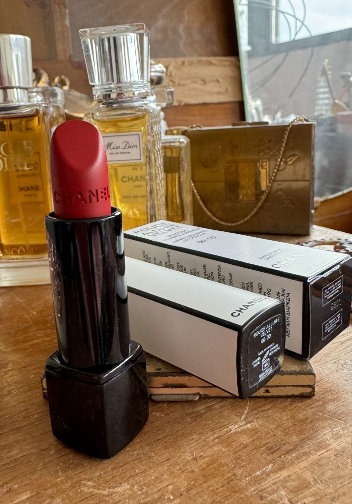 Lipstick on a dresser with perfume bottles