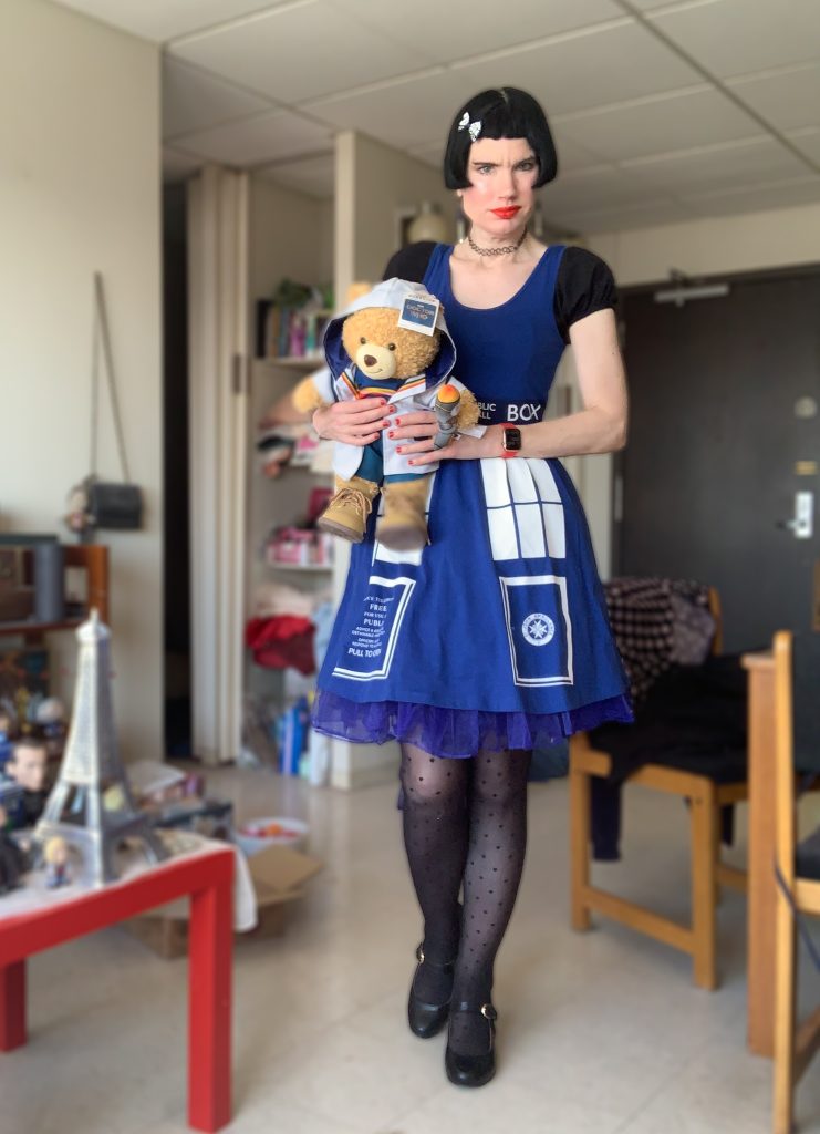 Me in a Tardis dress holding my 13th Doctor bear