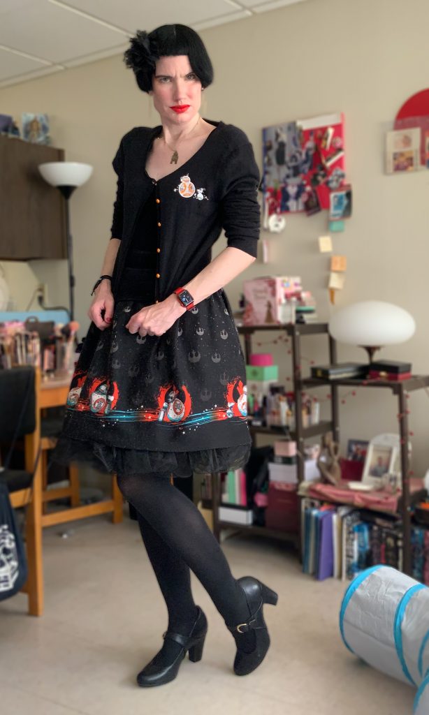 Me wearing a skirt and sweater with Star Wars droids on it.