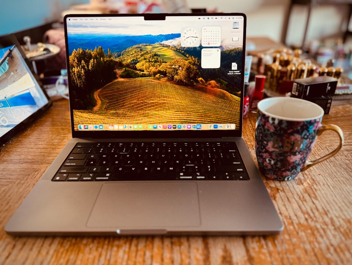 MacBook on table with coffee mug